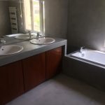 La salle de Bains qui fait la belle part au Béton Ciré avec des touches de bois précieux
